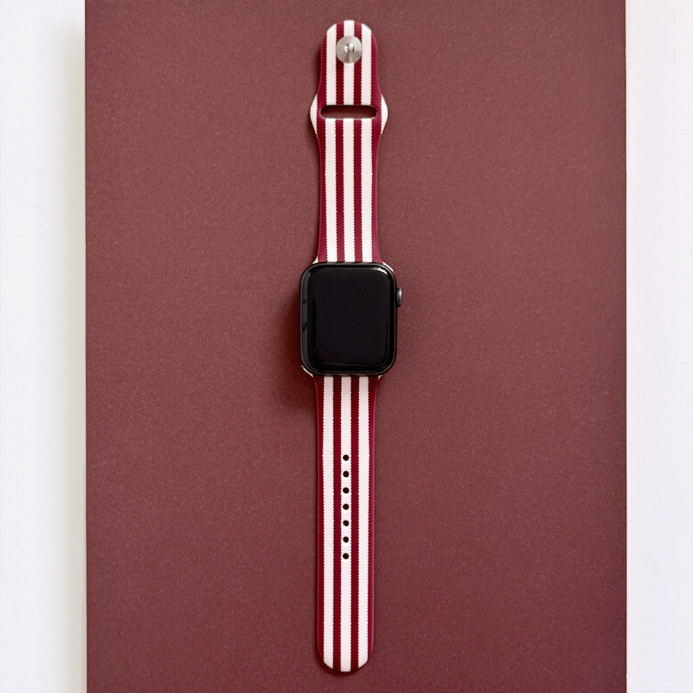 Burgundy and light pink striped Apple Watch Strap, attached to a black Apple Watch.