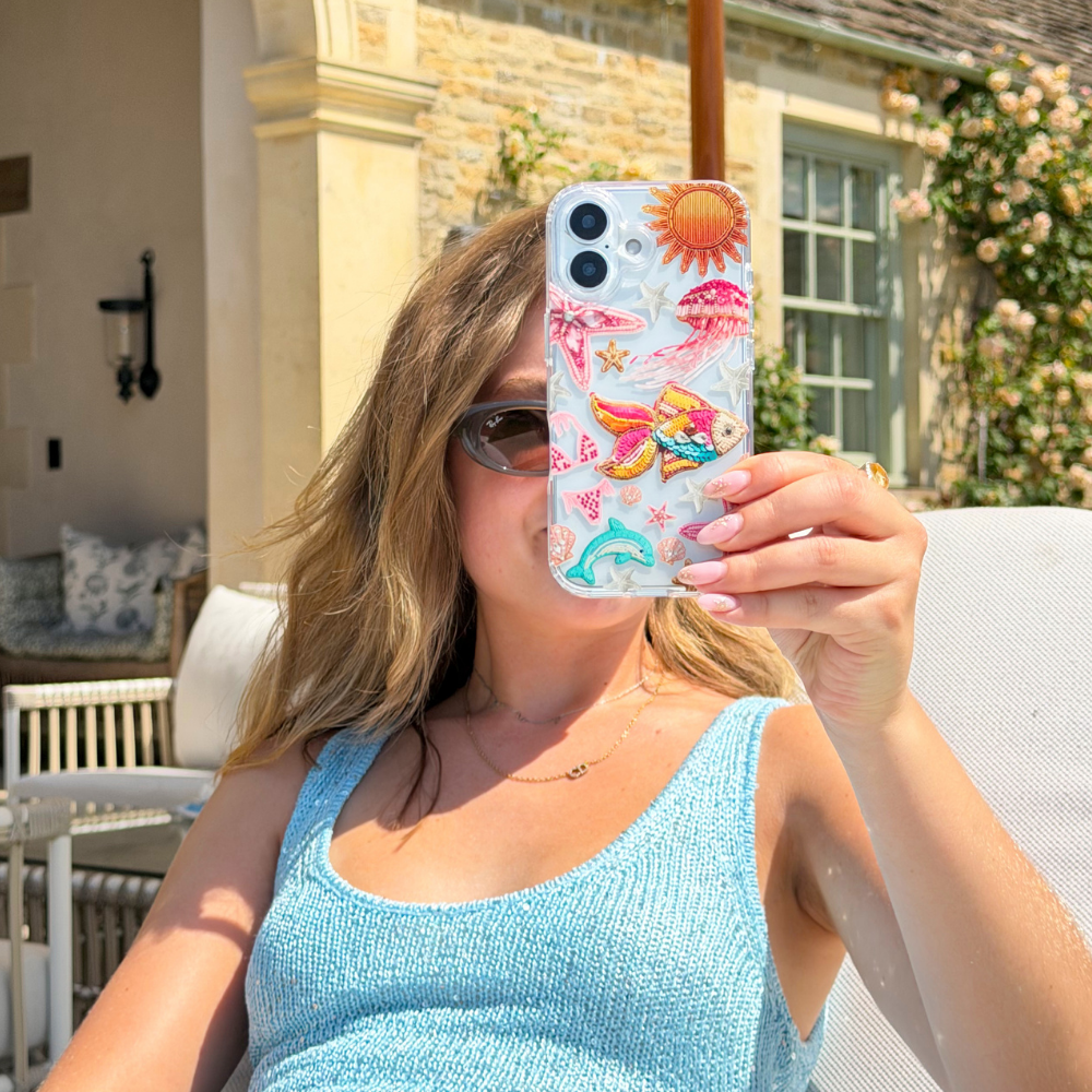 Girl on sun bed holding Pink Paradise Phone Case