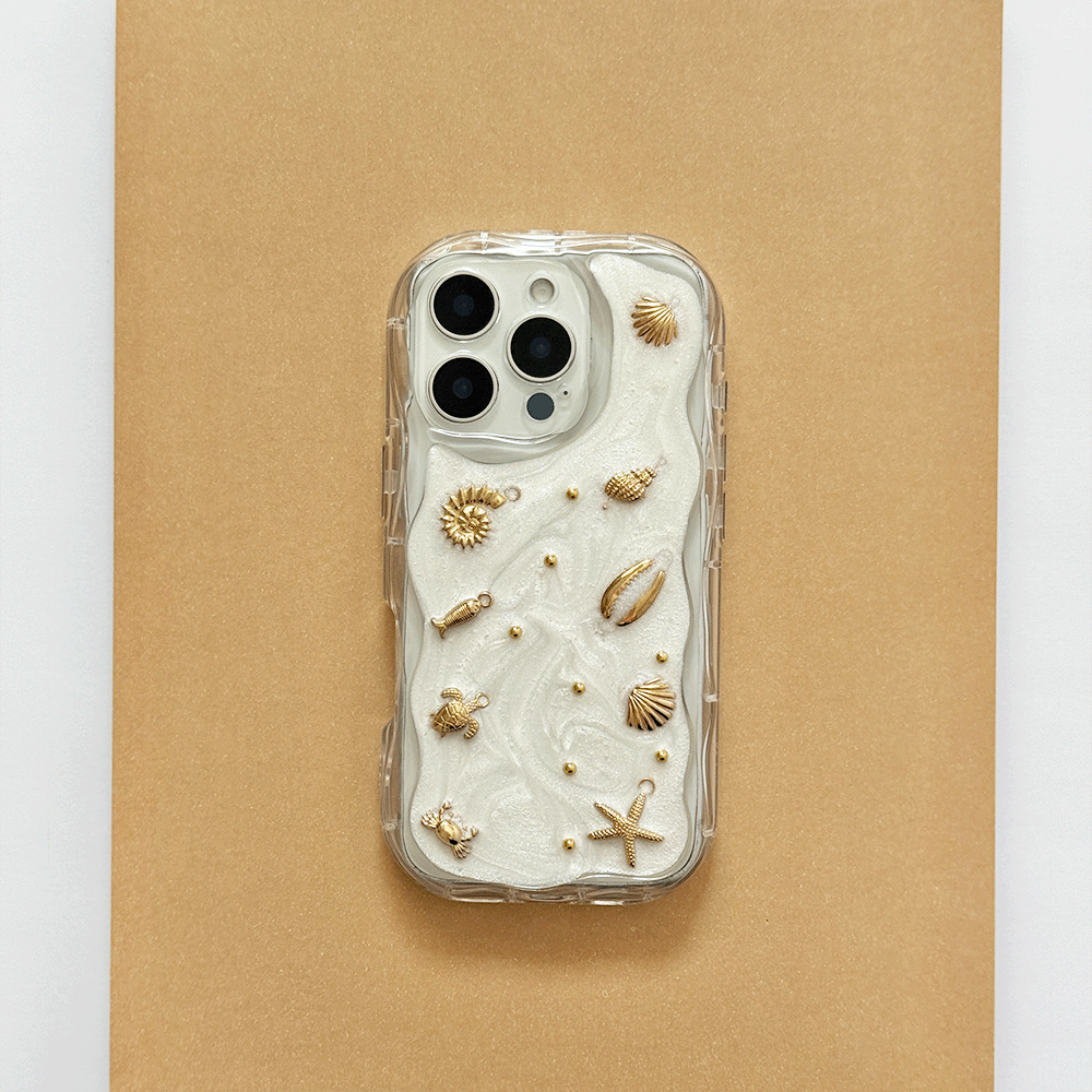 A clear phone case with a white pearlescent background, gold seashell and starfish embellishments, shown on a gold background.
