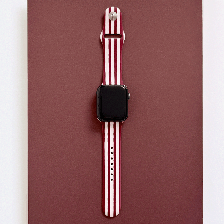 Burgundy and light pink striped Apple Watch Strap, attached to a black Apple Watch.
