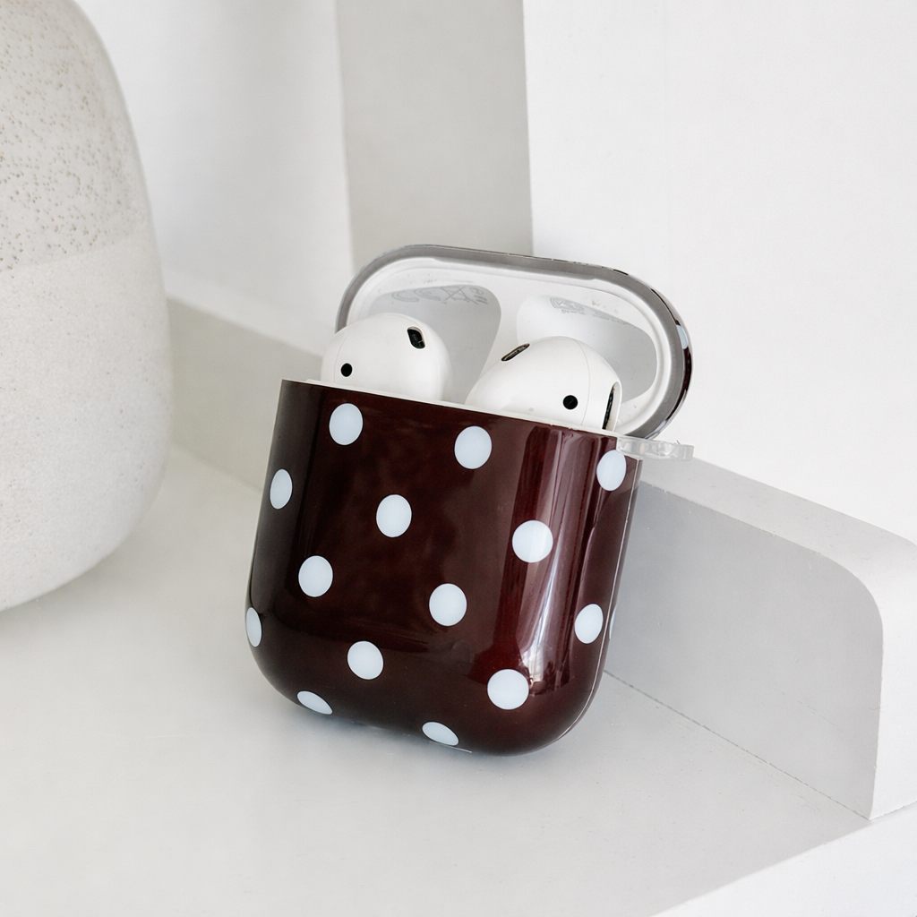 Showing the inside of brown AirPods Case with blue polka dot design.