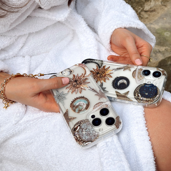 Girl holding both celestial and pastel celestial phone case wearing dressing gown