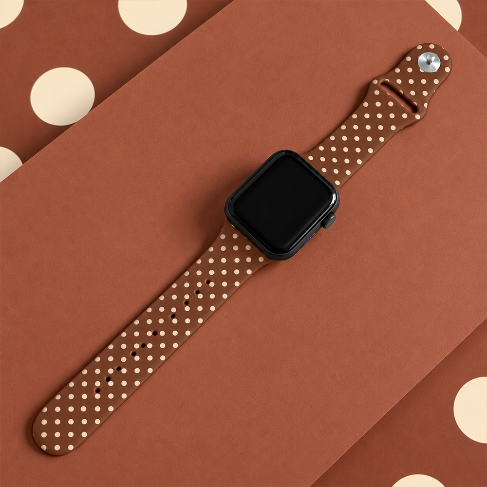 Brown silicone sport band with small cream polka dots, attached to a black Apple Watch smartwatch.