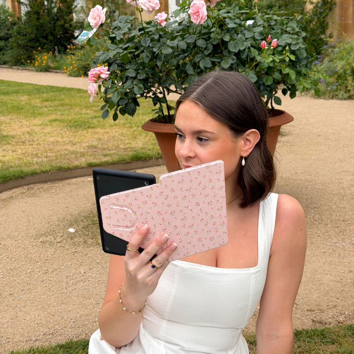 girl in park reading from ditsy floral pink kindle