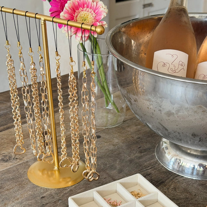 Gold stand showing the different phone straps from the charm studio.