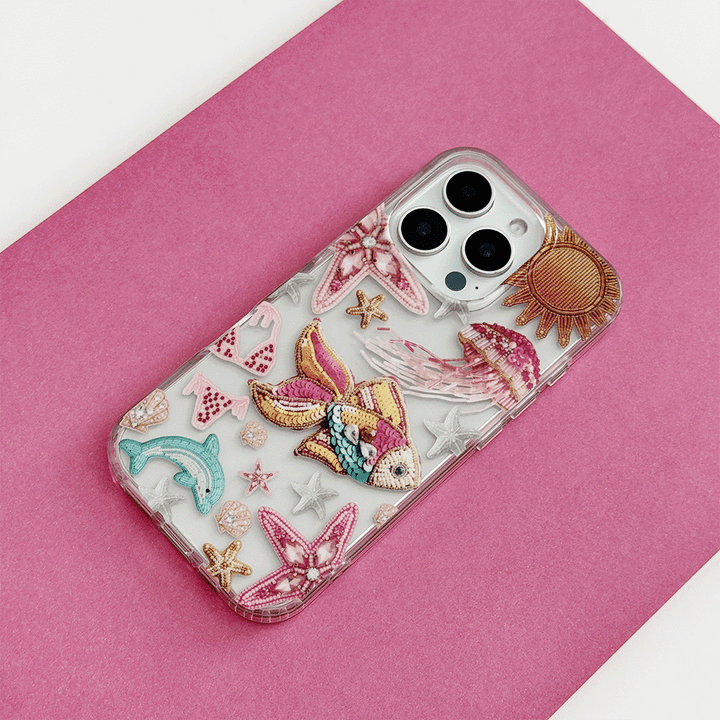 Coconut Lane clear phone case with pink trim and colorful embroidered patch designs.