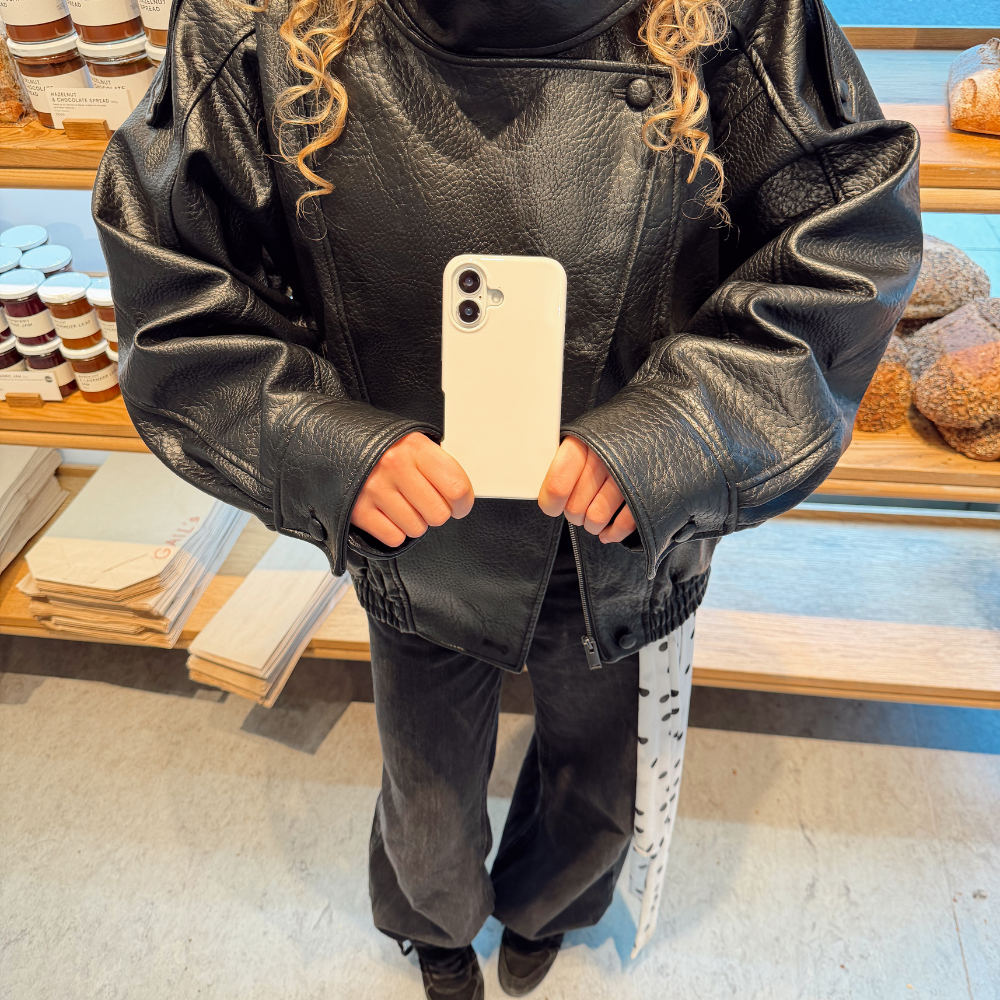 Girl in the bakery posing with the Tough Phone Case in Cloud Dancer