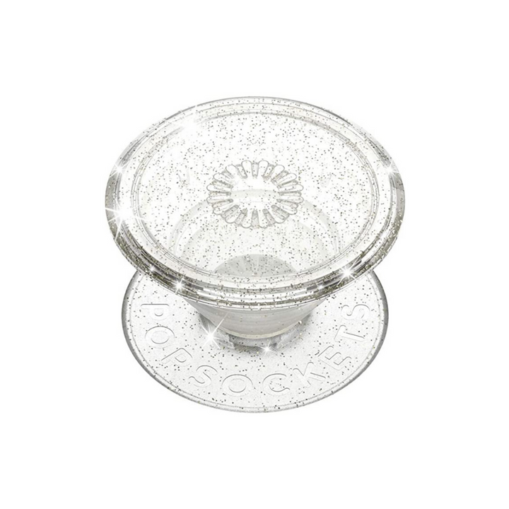 Introducing the Coconut Lane PopSocket Grip in Clear Silver Glitter: a transparent, collapsible grip featuring a circular base inscribed with "PopSockets." This dazzling accessory sparkles when light hits it, adding a touch of glam to your device.