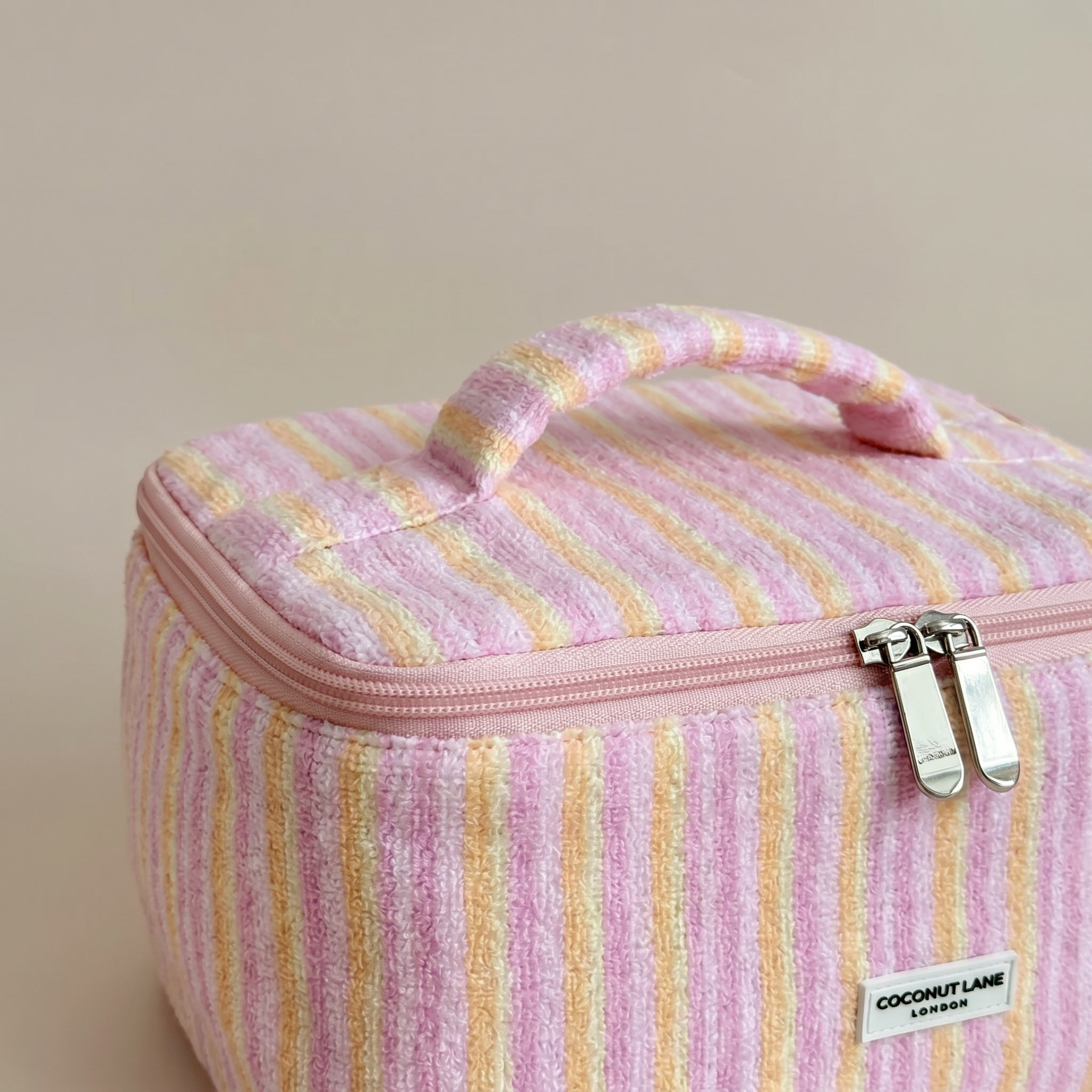 Pink, orange and yellow striped Vanity Bag in towel fabric with Coconut Lane logo.