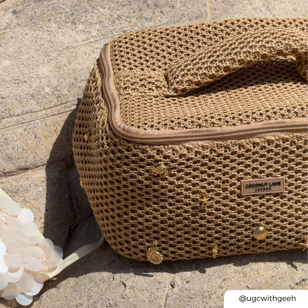 Brown textured vanity bag with gold accents on a stone surface