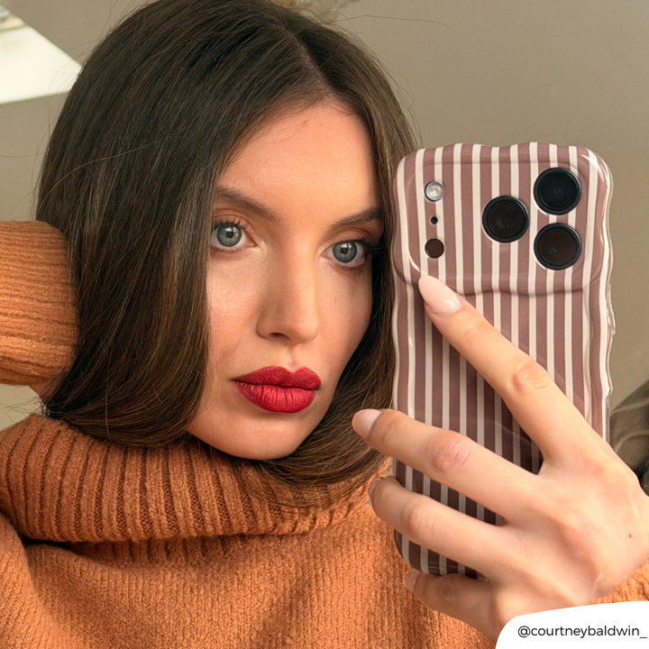 Girl wearing red lipstick taking a mirror selfie with the Wavy Chestnut Stripes Phone Case