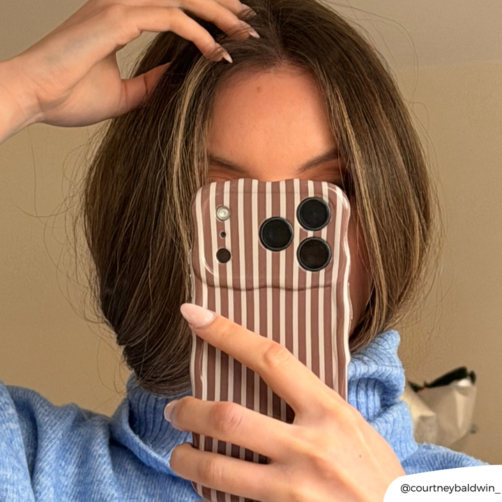 Girl in a blue knit jumper taking a close up mirror selfie with Wavy Phone Case Chestnut Stripes