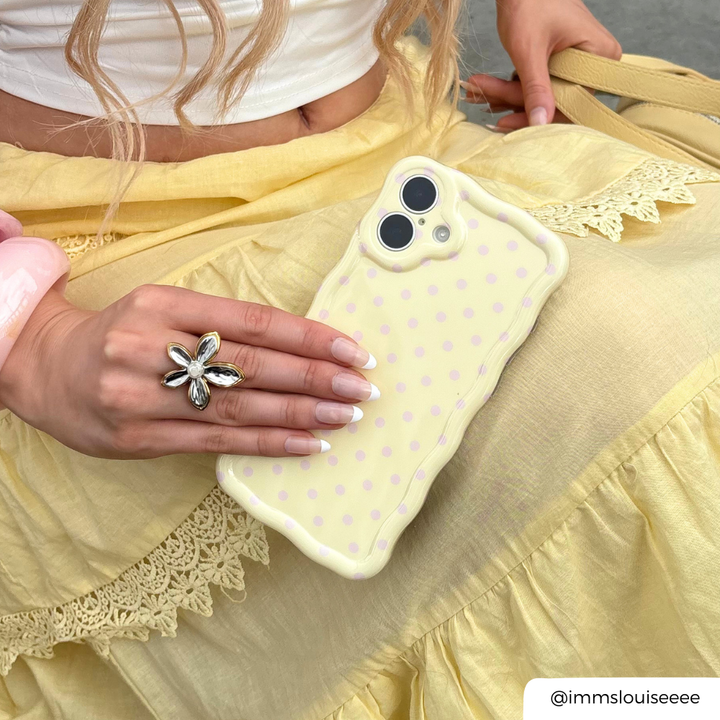 Wavy Phone Case Butter Blush being held by yellow flowy skirt