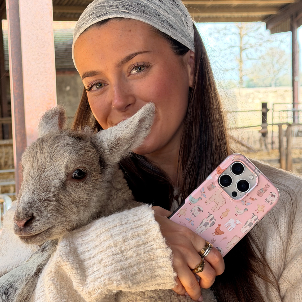 girl holding lamb and countyside cuties tough phone case in hand