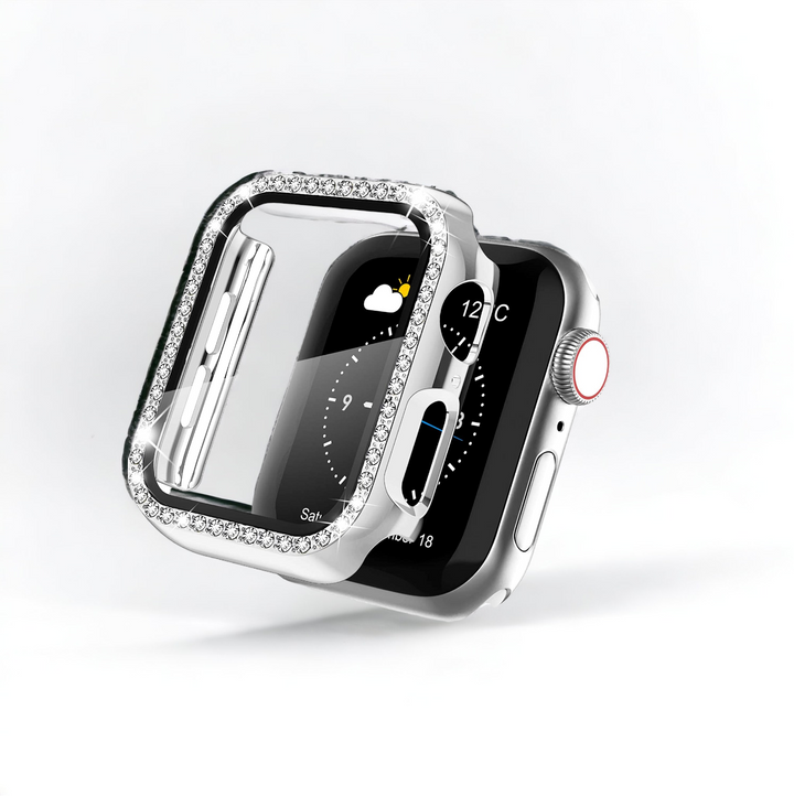 A close-up of a silver Apple Watch with a rectangular screen displaying weather information, partially covered by Coconut Lane's 2-in-1 Apple Watch Case & Built-In Screen Protector - Silver Diamante. The shock-proof, transparent case is adorned with small, shiny crystals along the edges. The background is plain white.
